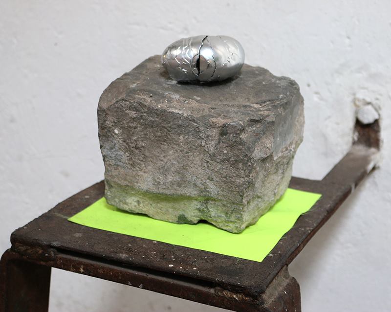 Raimundo Edwards, La Bienvenida, 2013, cáscara de huevo revestida en pintura cromo acrilica, adoquín encontrado y tela. Cortesía del artista