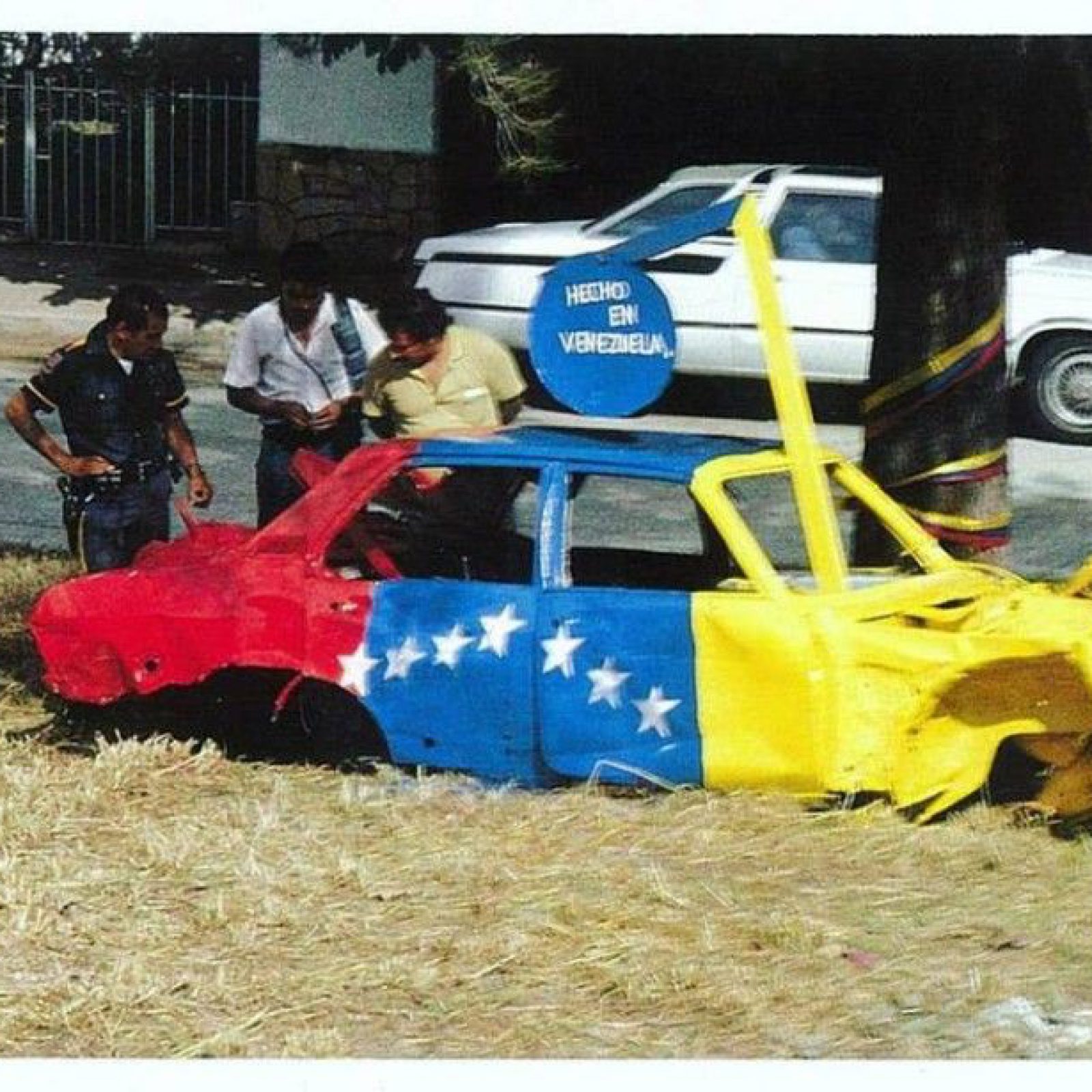 Juan Loyola, intervención con bandera venezolana sobre auto abandonado, Caracas,1980