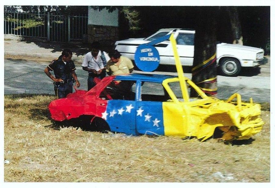 Juan Loyola, intervención con bandera venezolana sobre auto abandonado, Caracas,1980