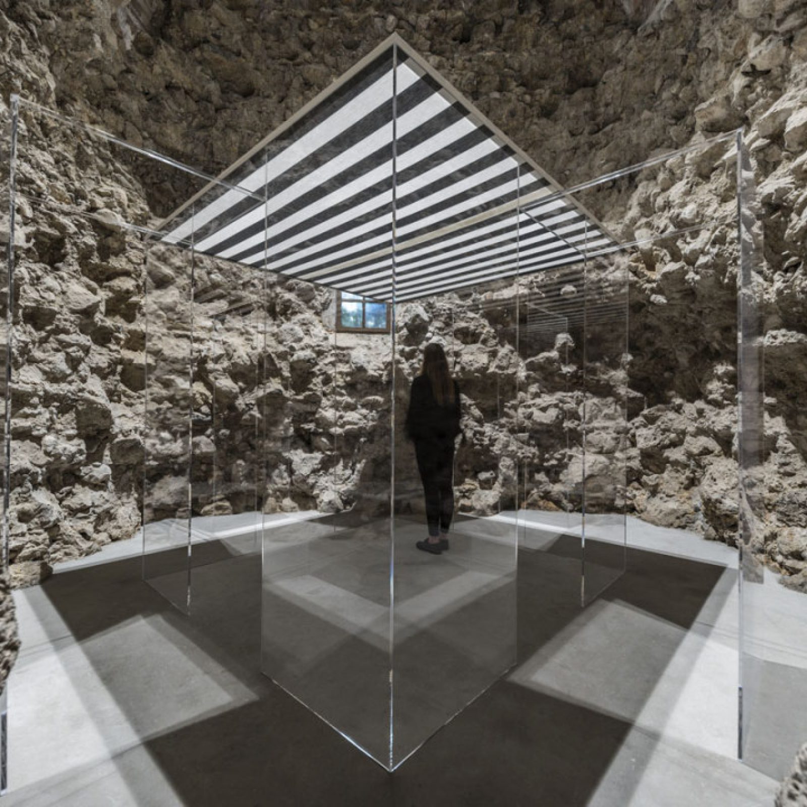 Daniel Buren, Photo-souvenir: ‘La Cabane éclatée II transparente' 2018, obra situada, plexiglás, madera, tela de algodón en blanco y negro alternada y tiras verticals de 8,7 cm cada una, luz eléctrica, 234,9 x 234,9 x 234,9 cm © Daniel Buren/ADAGP, París. Foto: Ela Bialkowska