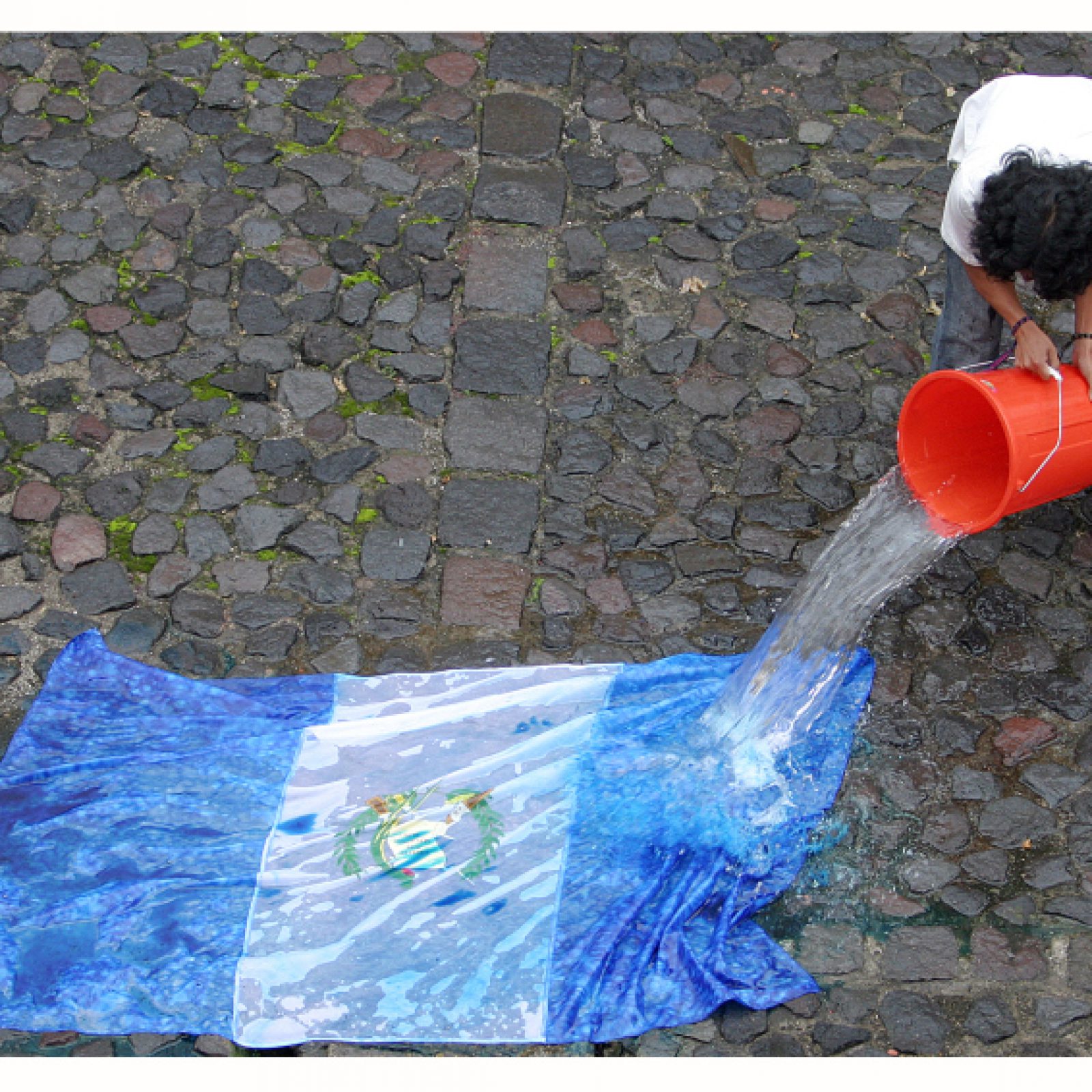 Fernando Poyón, Bandera, 2008, parte de la exposición “Horror Vacui. Los Desaparecidos”. Acción (con la acción del agua una bandera desaparece). Cortesía del artista
