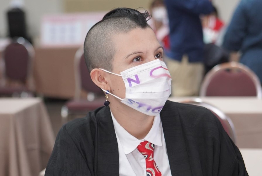 J Triangular usando una máscara que dice "No more stigma"