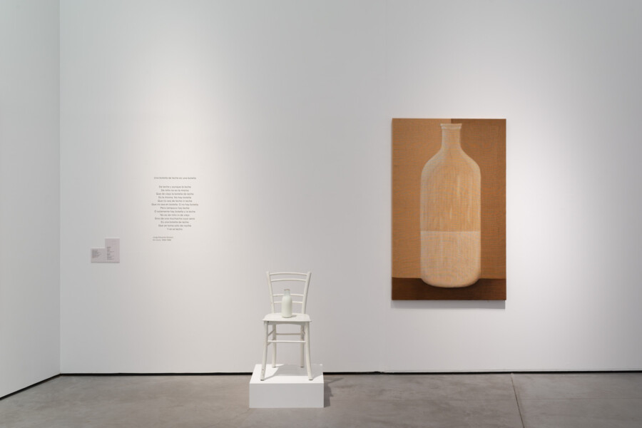 una silla blanca con una botella blanca encima y al lado una pintura de una botella con leche hasta la mitad de colores ocres