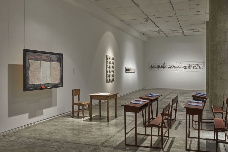 Nereida Apaza Mamani, Utopía de la educación. Instalación de 8 cuadernos Patria, 23 x 17 cm c/u, 12 páginas en promedio por cuaderno, 170 x 90 x 10 cm. Vista de la exposición “Escuchar con las manos”, ICPNA, Lima, 2024. Foto: Juan Pablo Murrugarra.