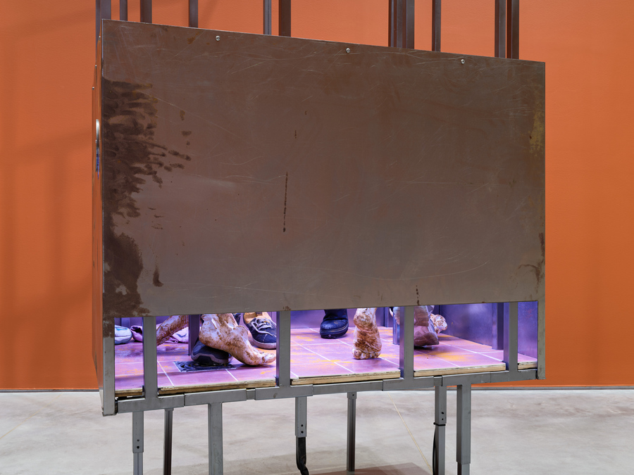 Osías Yanov (Argentina, 1980), Cuarto oscuro, tetera, cuarto oscuro, mi lugar, baño, síntoma del mundo, 2023. Hierro, yeso, azulejos, rejilla, zapatillas, cúrcuma, tubo de luz LED. Foto: Sebastian Bach