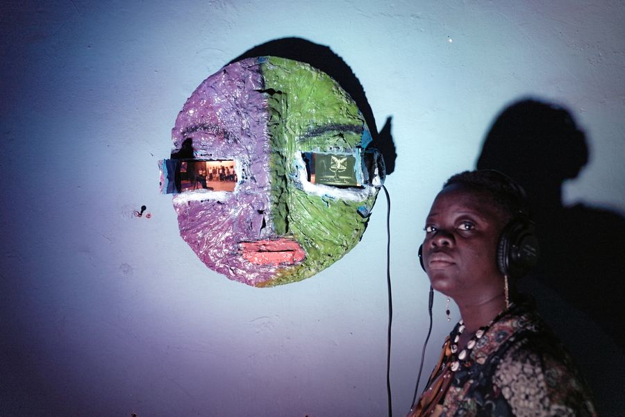 Sarah Ndele in front of her installation Tell Me the Story, 2023 © Photo: Nathan Bushiru, Courtesy Sarah Ndele