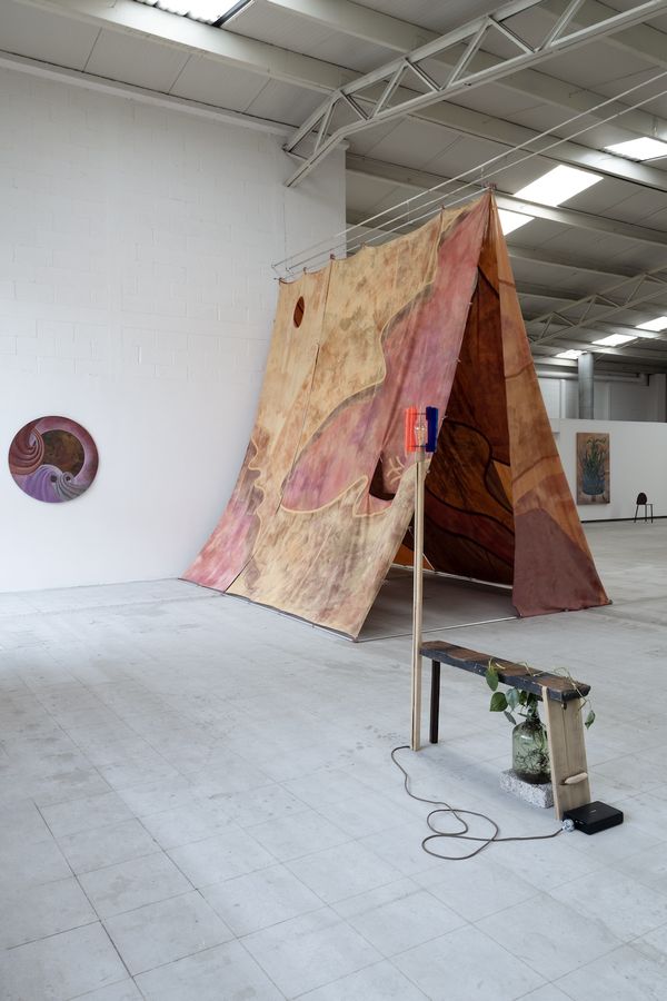 Al fondo: Celeste, Un temblor pequeño movió el centro, 2024. Pigmentos y base acrílica sobre tela de algodón teñida, 370 x 390 x 340 cm | Al frente: Javier Lázaro, Instrucciones para cuidar una silla, 2025. Madera viva y madera muerta. Medidas variables. Foto: Rubén Garay. Cortesía: guadalajara90210