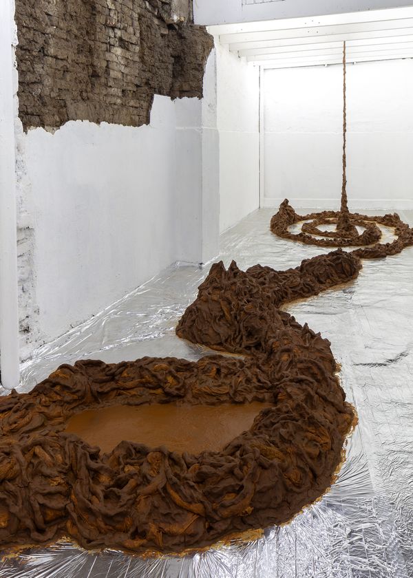 Ángela Jiménez, Encuentro, 2025. Greda del valle de Pomaire, arena del río Maipo, agua, toallas y sábanas desechadas, madera, aluminio, hierro. Dimensiones variables. Vista de instalación en Sagrada Mercancía, Santiago. Foto: Felipe Ugalde.